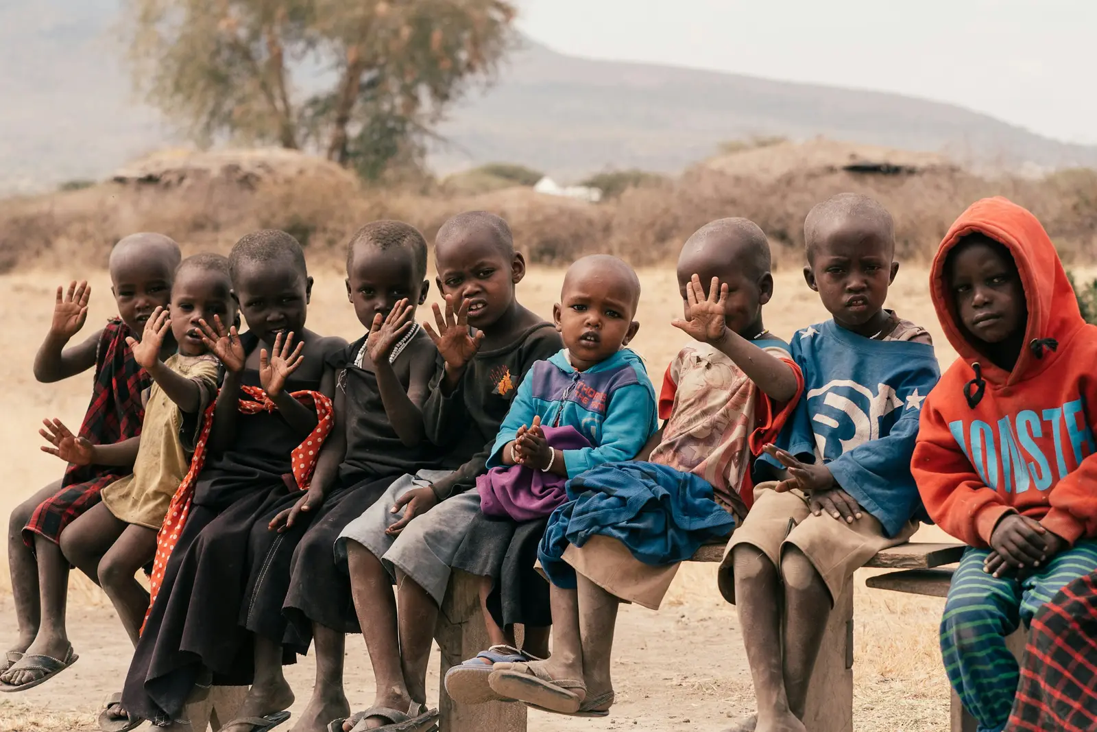 Children sitting together on a bench in a pastoralist village in the East African drylands
